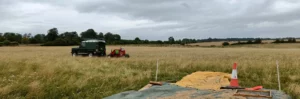 A landrover oulling a seed harvester in a field