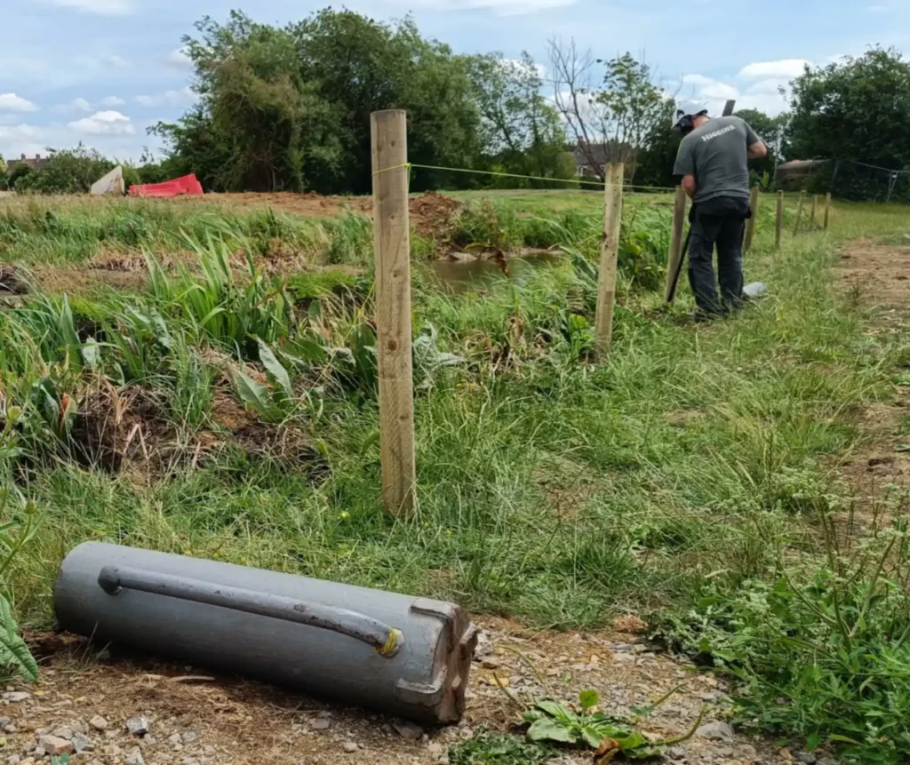 Post Rammer in forground. Man tampering in a post
