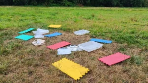 coloured mats and sample trays on the ground in a field
